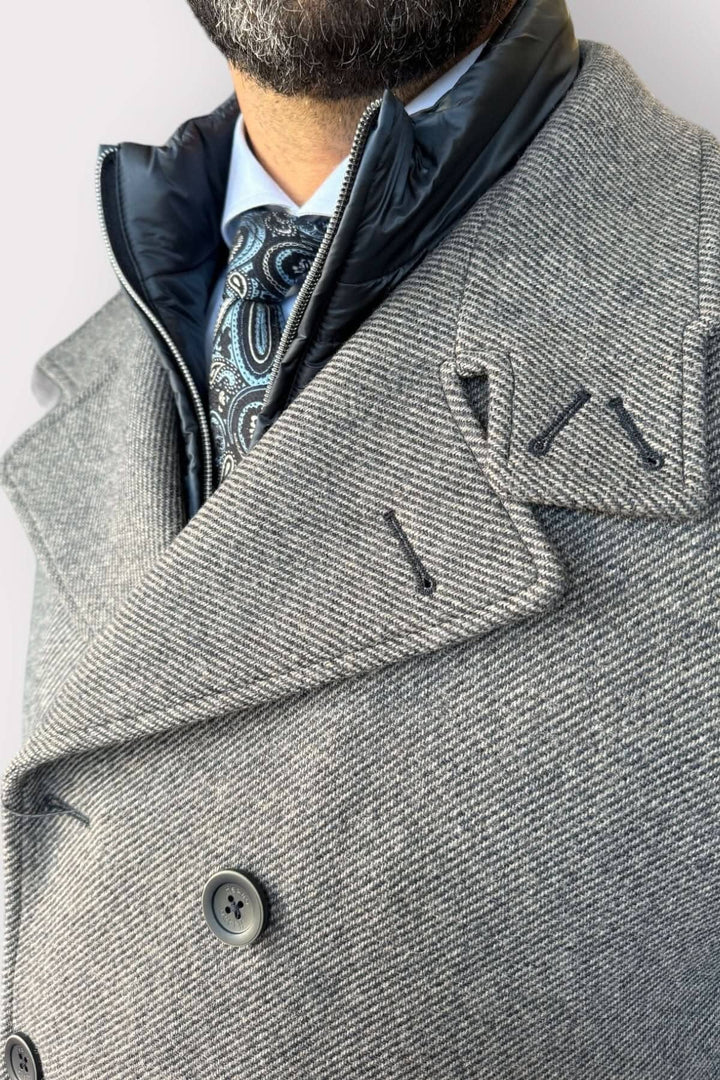 Manteau caban doublé élégant avec col montant et boutons, porté avec une cravate stylée.