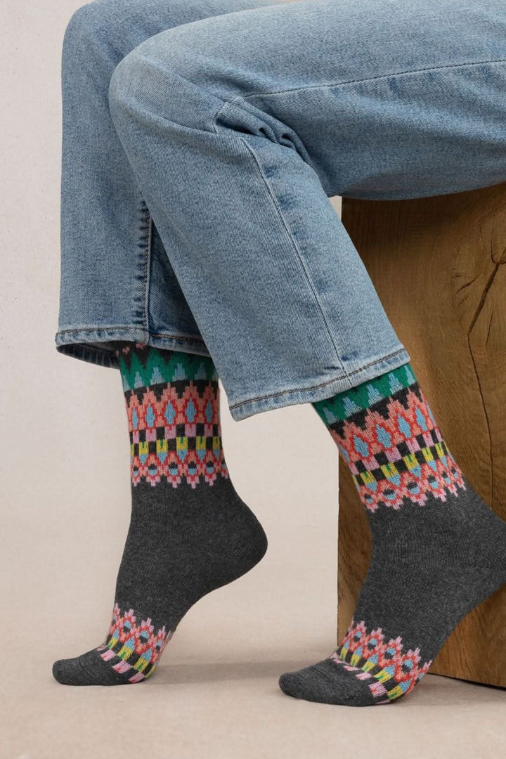 Chaussettes jacquard colorées en cachemire portées avec un jean, offrant confort et chaleur.