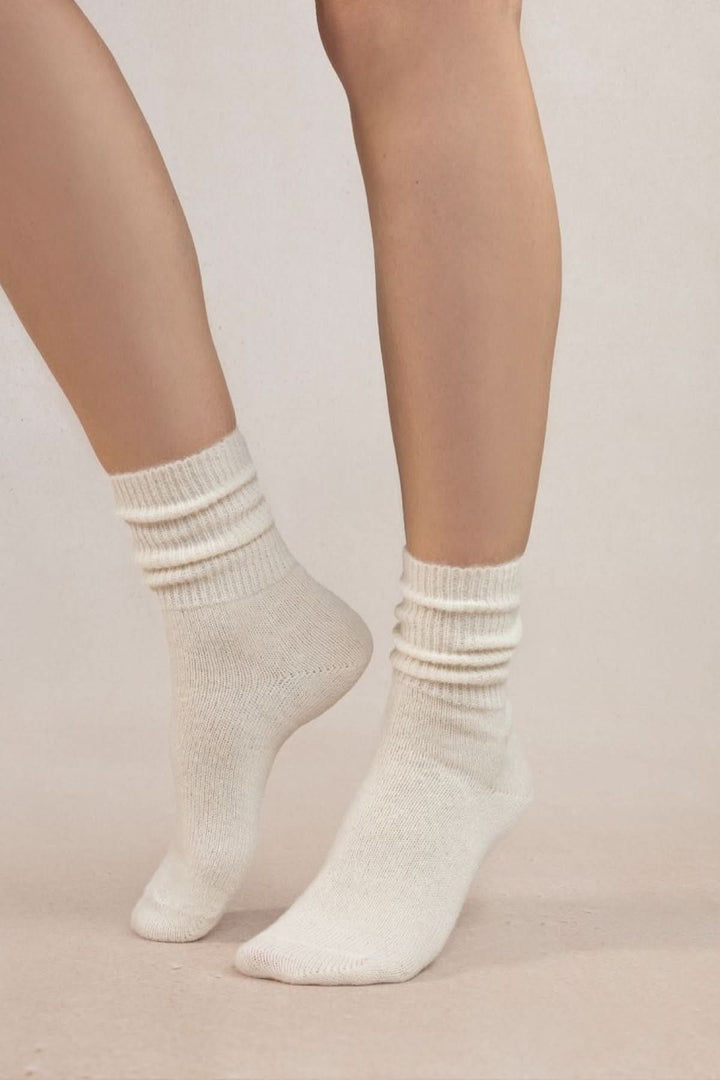 Chaussettes en laine alpaga blanches, douces et chaudes, avec bord-côtes, parfaites pour un look cosy en hiver.