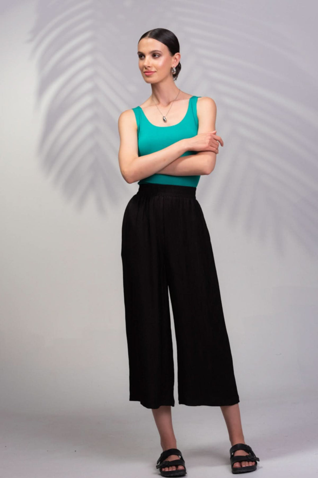 Modèle portant un pantalon texturé noir avec une coupe décontractée, idéal pour temps chaud et look décontracté.