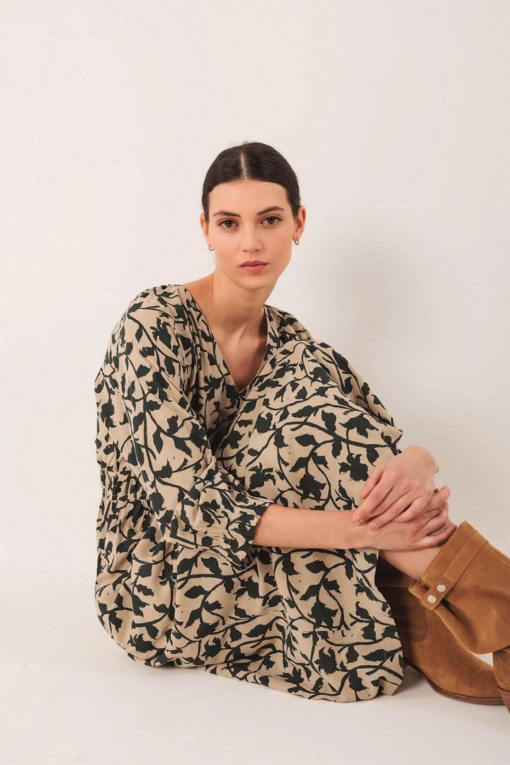 Robe longue fluide avec imprimé botanique, décolleté en V, portée avec des bottes en cuir.