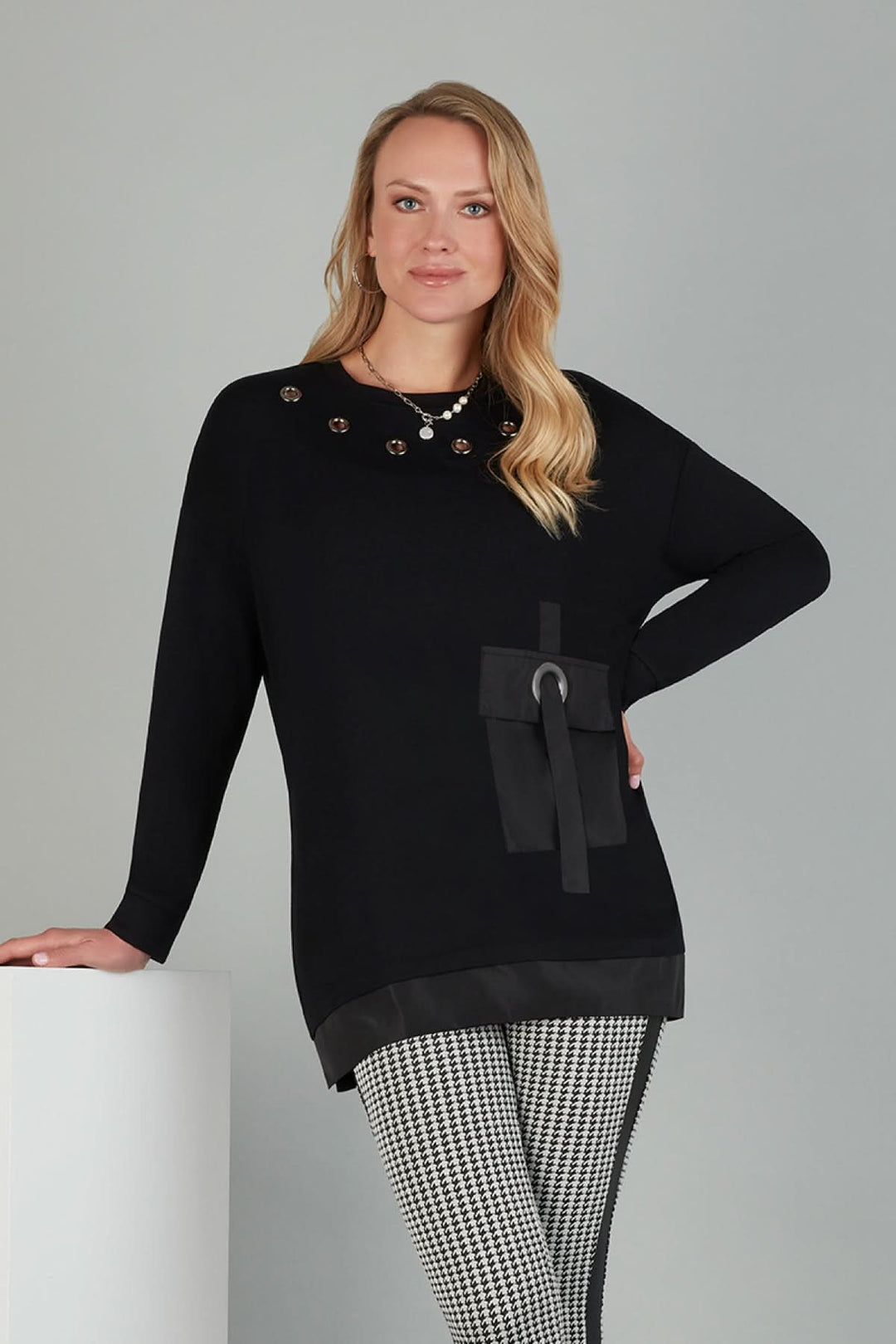 Tunique noire avec œillets argentés, manches longues, poche en satin, style décontracté et ample.