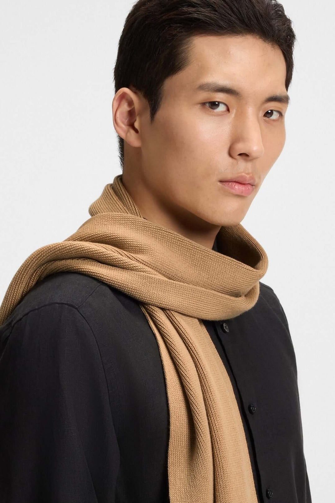 Foulard de laine vierge Boss porté par un modèle, style élégant avec maille Raschel douce et logo discret, idéal pour l’hiver.