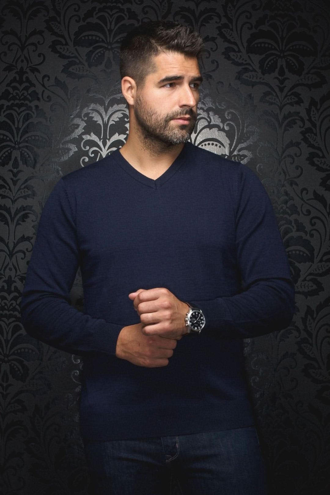 Homme portant un chandail col en V en mérinos marine, ajustement confortable et élégance raffinée.