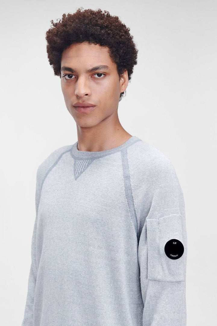 Pull en coton vanisé gris avec col ras du cou et poche sur la manche, détail en verre de lunette C.P. Company.