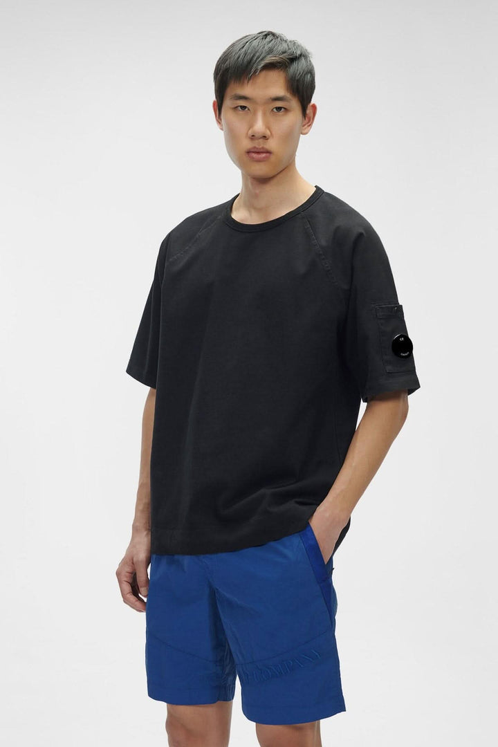 T-shirt en jersey épais noir avec col ras du cou et détail en verre de lunette sur la manche.