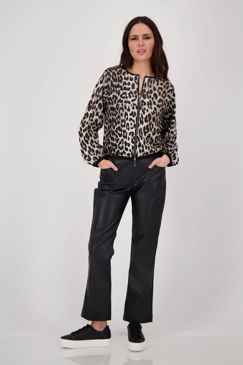 Femme portant une veste léopard élégante avec pantalon noir, style moderne et audacieux, look sophistiqué.