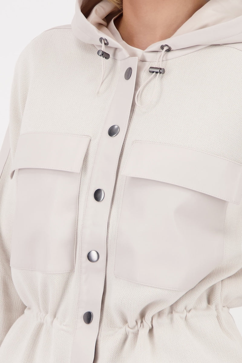 Veste à capuchon beige avec cordon de serrage et poches poitrine pour un style décontracté.