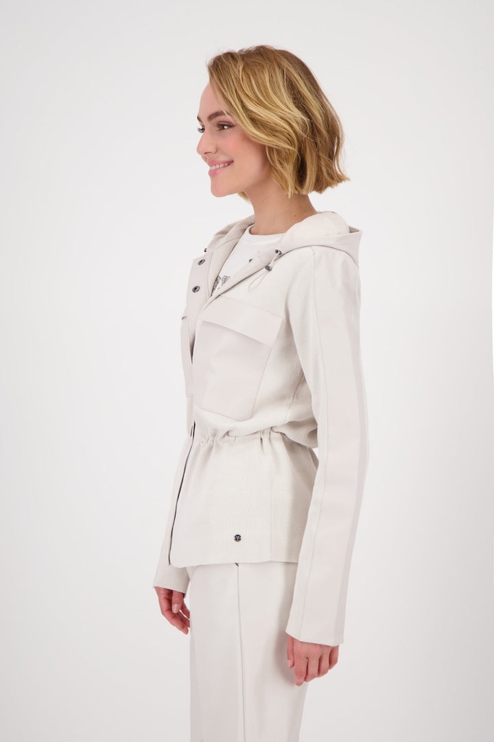 Veste à capuchon beige avec cordon de serrage, présentée sur un modèle féminin en profil.