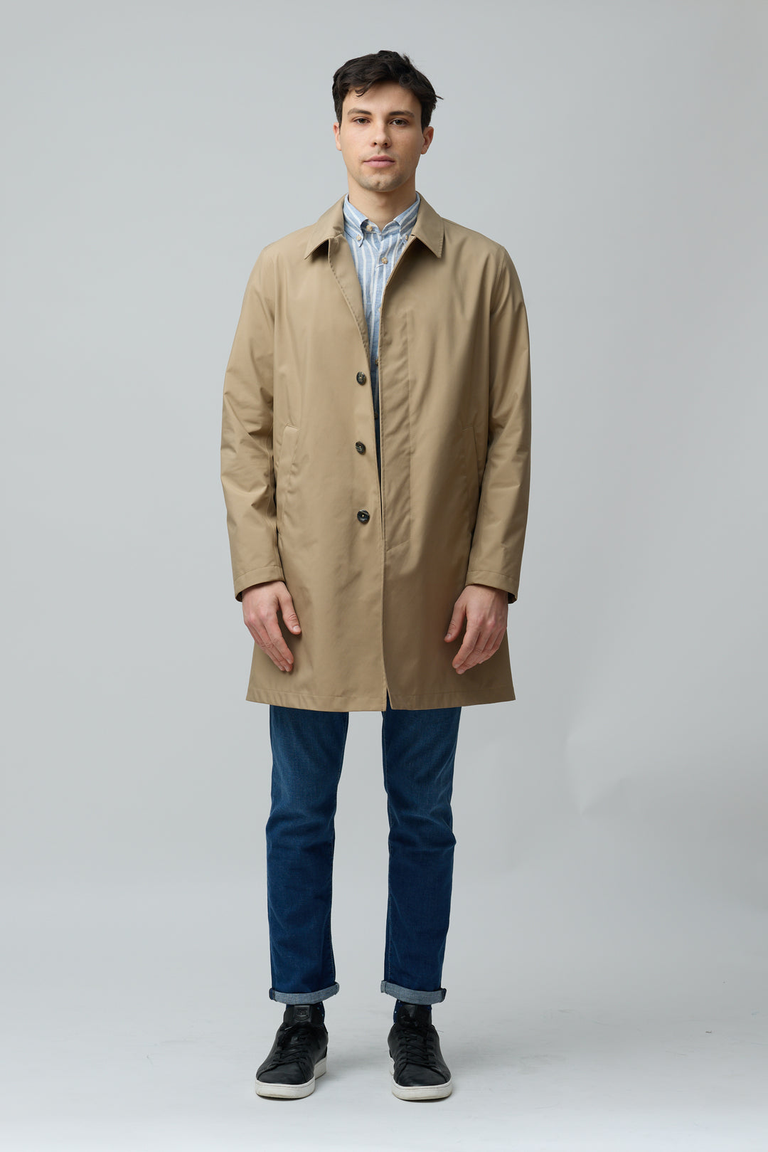 Homme portant un imperméable en microfibre technique beige, design moderne et épuré, idéal pour mi-saison en ville.