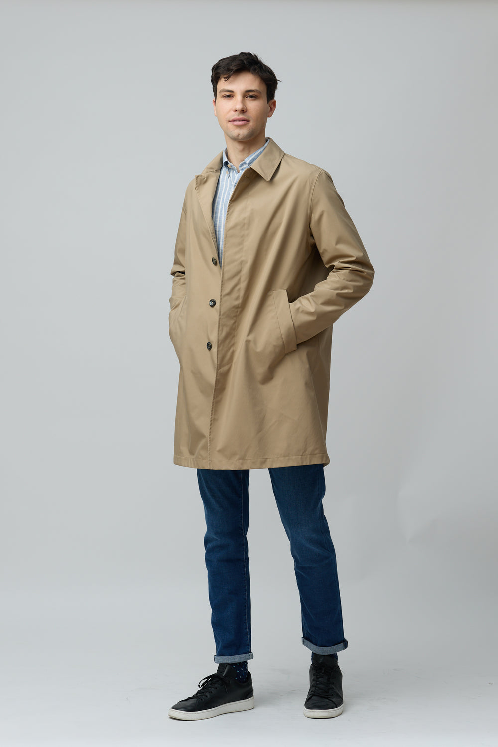 Homme portant un imperméable en microfibre technique avec une allure moderne et épurée, idéal pour mi-saison en ville.