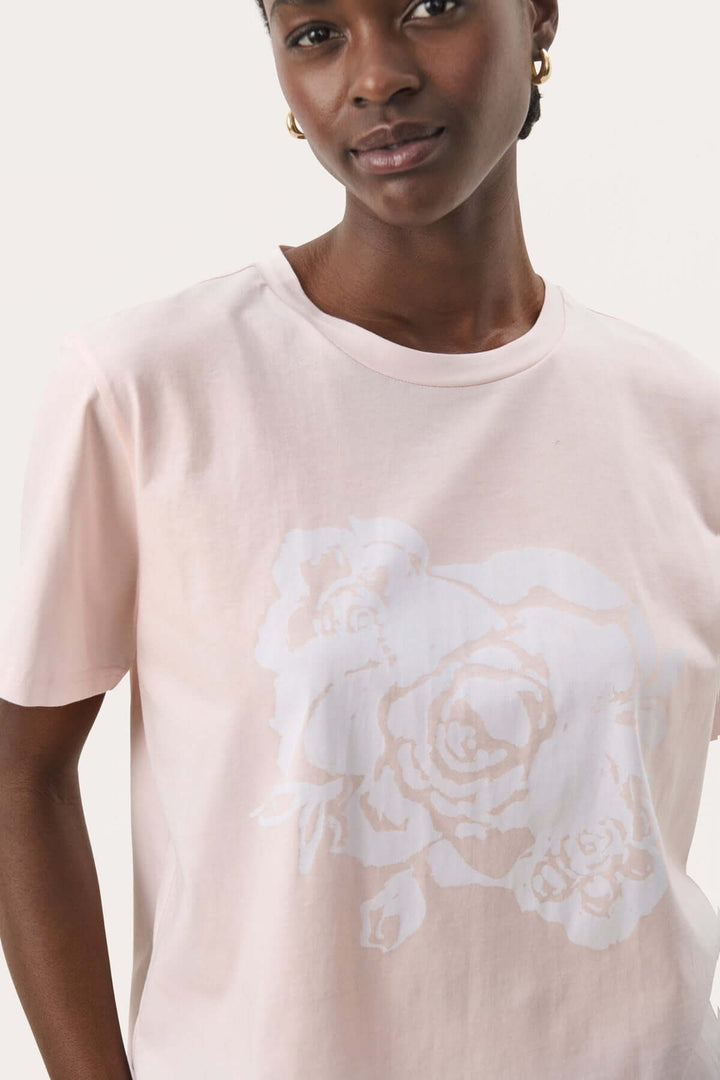 T-shirt Nahid en coton biologique, rose clair avec imprimé floral blanc, style décontracté et confortable.