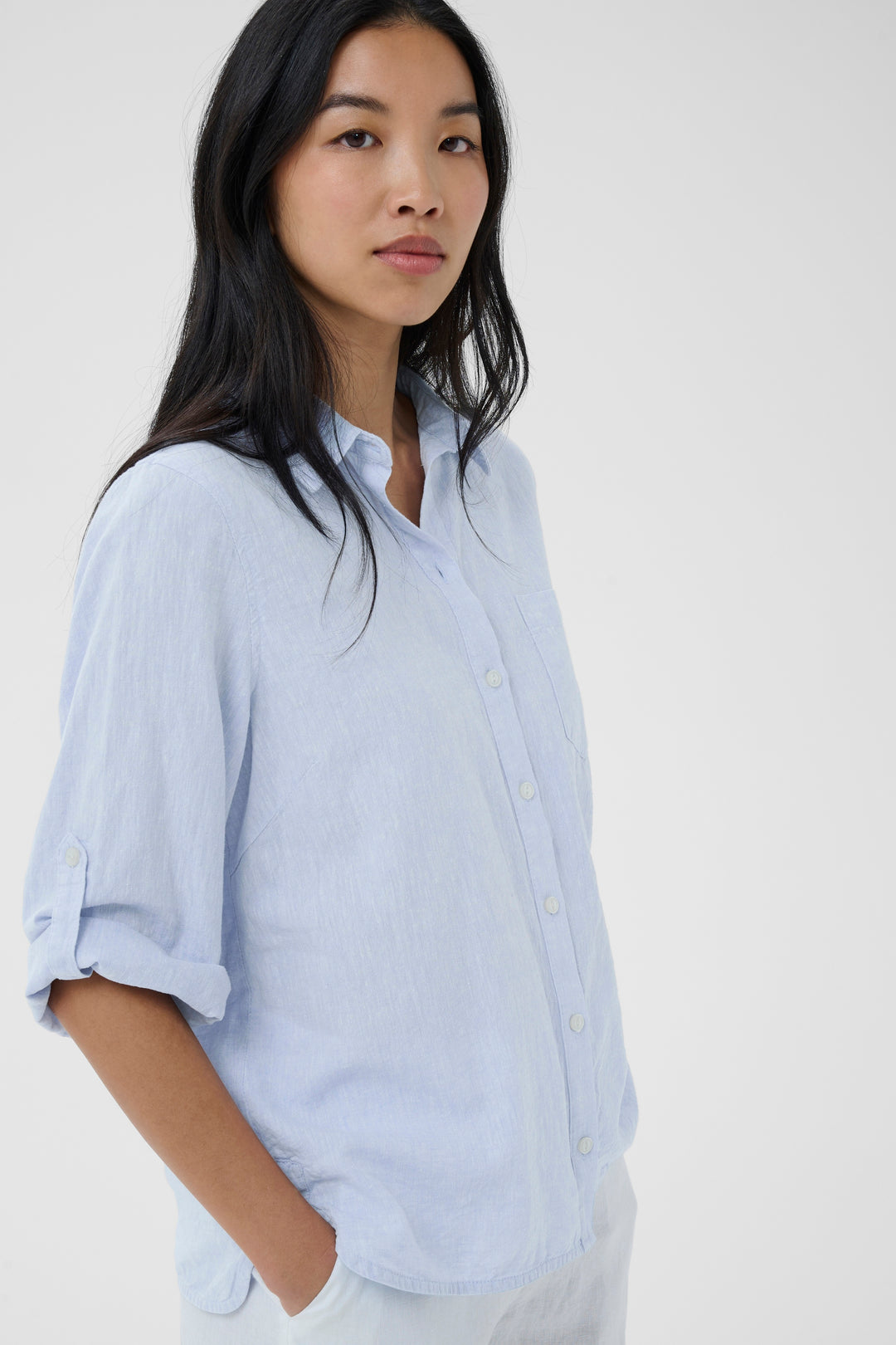 Femme portant la chemise rayée Cindie avec une coupe fluide et manches retroussées pour un look décontracté.