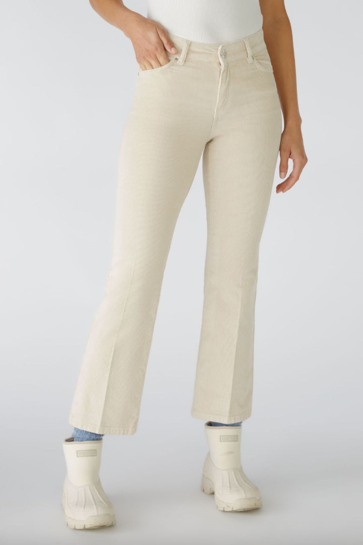 Pantalon en velours côtelé léger, légèrement évasé, avec zip et bouton, couleur beige, longueur raccourcie.
