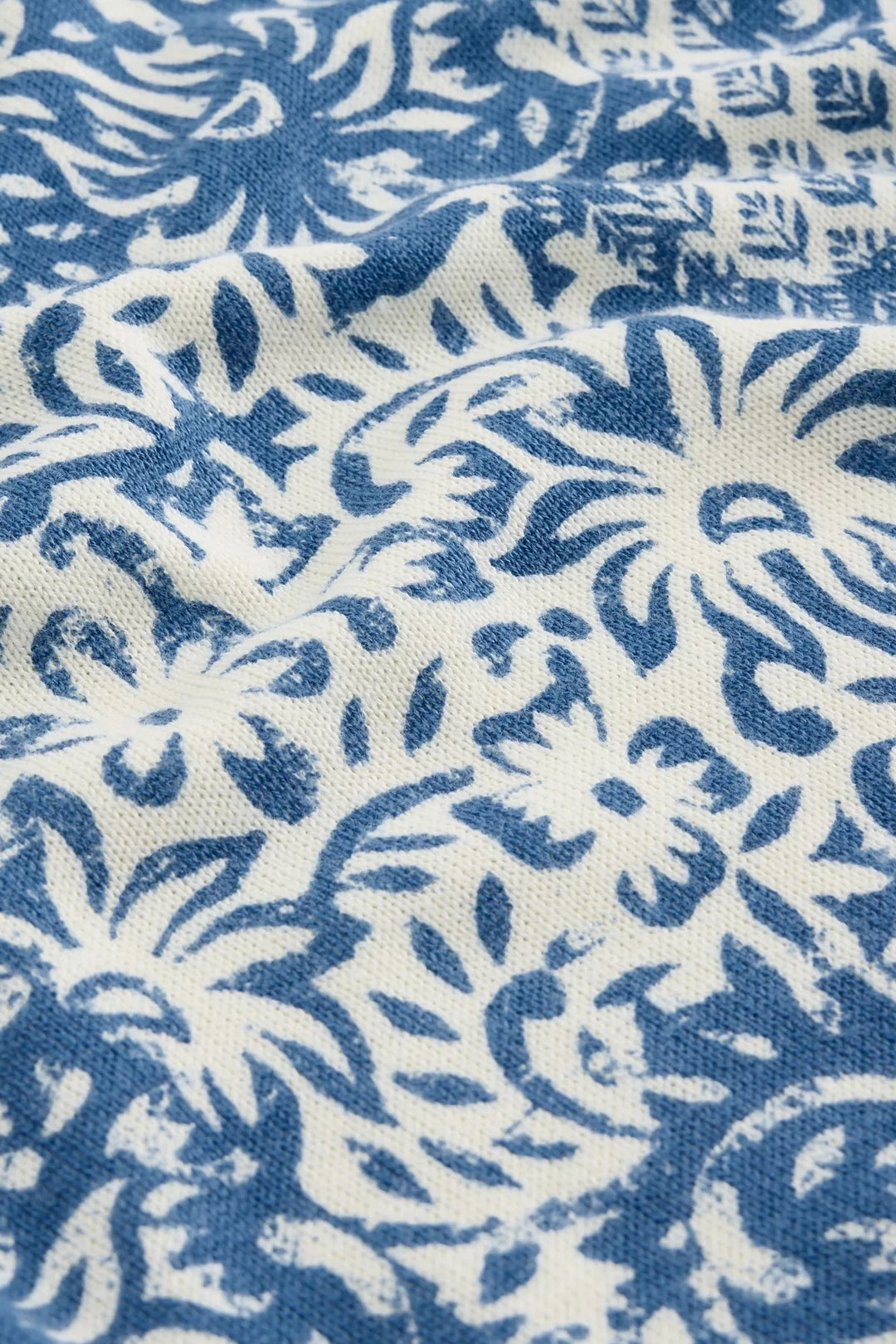 Motif floral bleu et blanc sur tissu, idéal pour un chandail imprimé moderne et confortable.