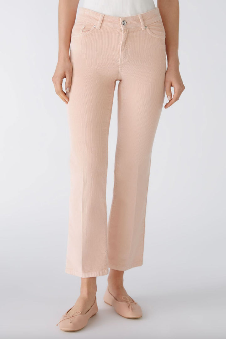 Pantalon en velours côtelé rose, légèrement évasé, longueur raccourcie, taille moyenne, style classique à cinq poches.