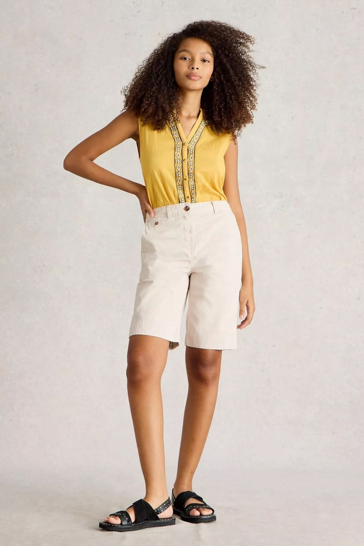 Model wearing Bermuda Hayley cotton shorts paired with a yellow top, showcasing a fresh summer look.