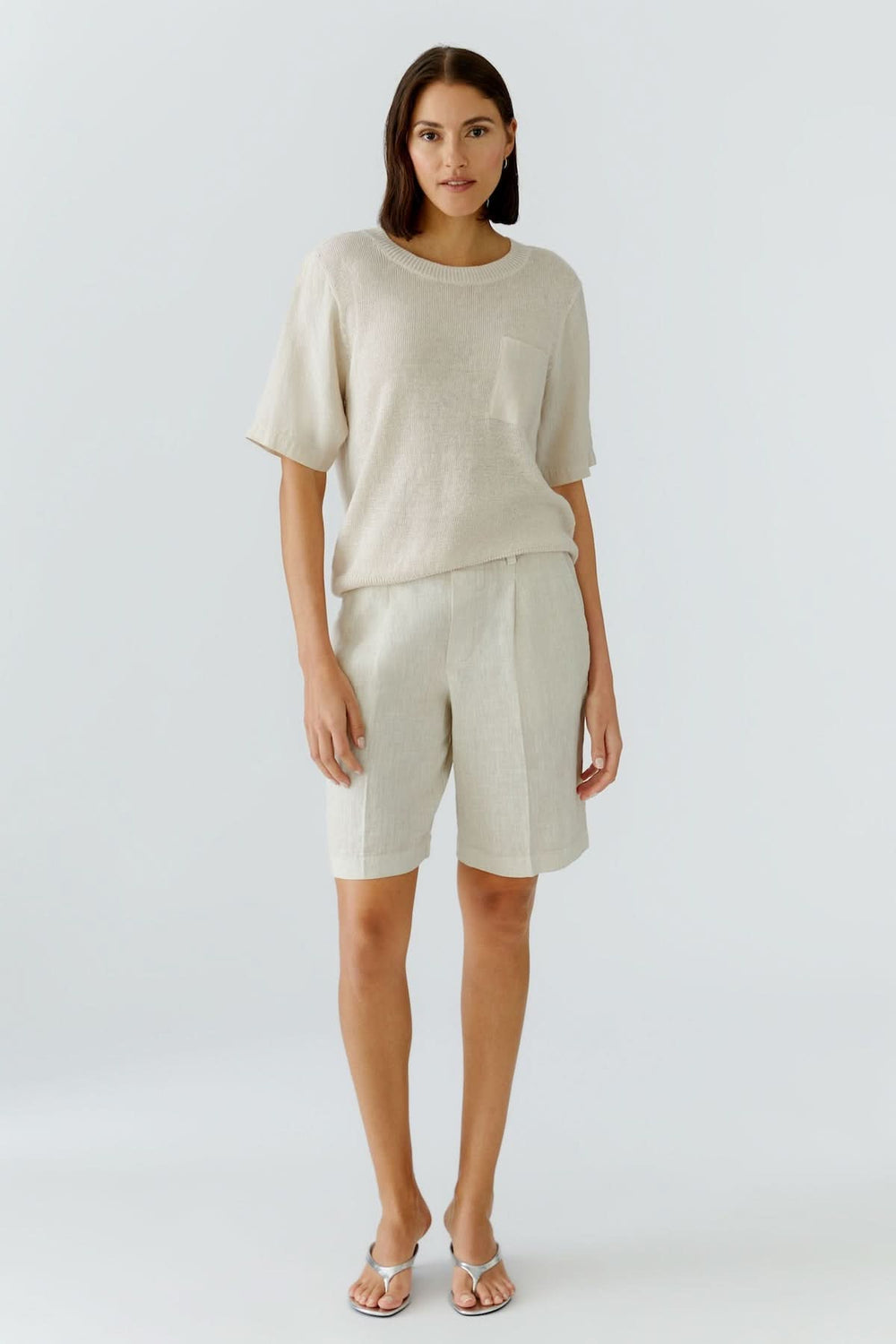 Femme portant un bermuda en lin moderne et estival, coupe droite élégante et confortable, idéal pour un look décontracté chic.