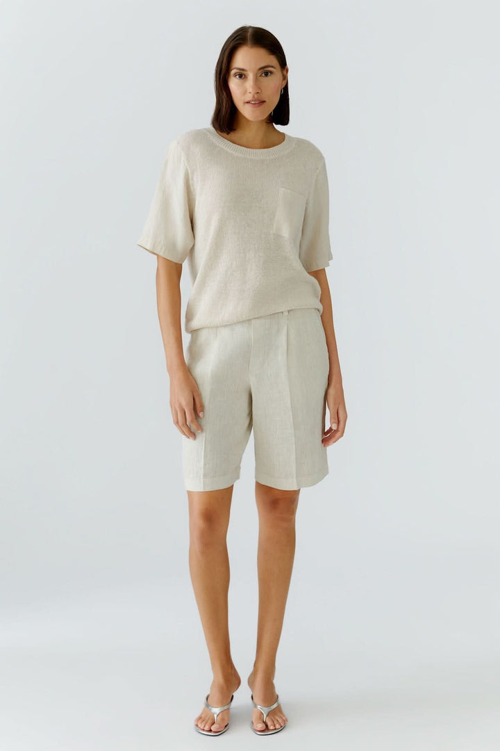 Femme portant un bermuda en lin moderne et estival, coupe droite élégante et confortable, idéal pour un look décontracté chic.