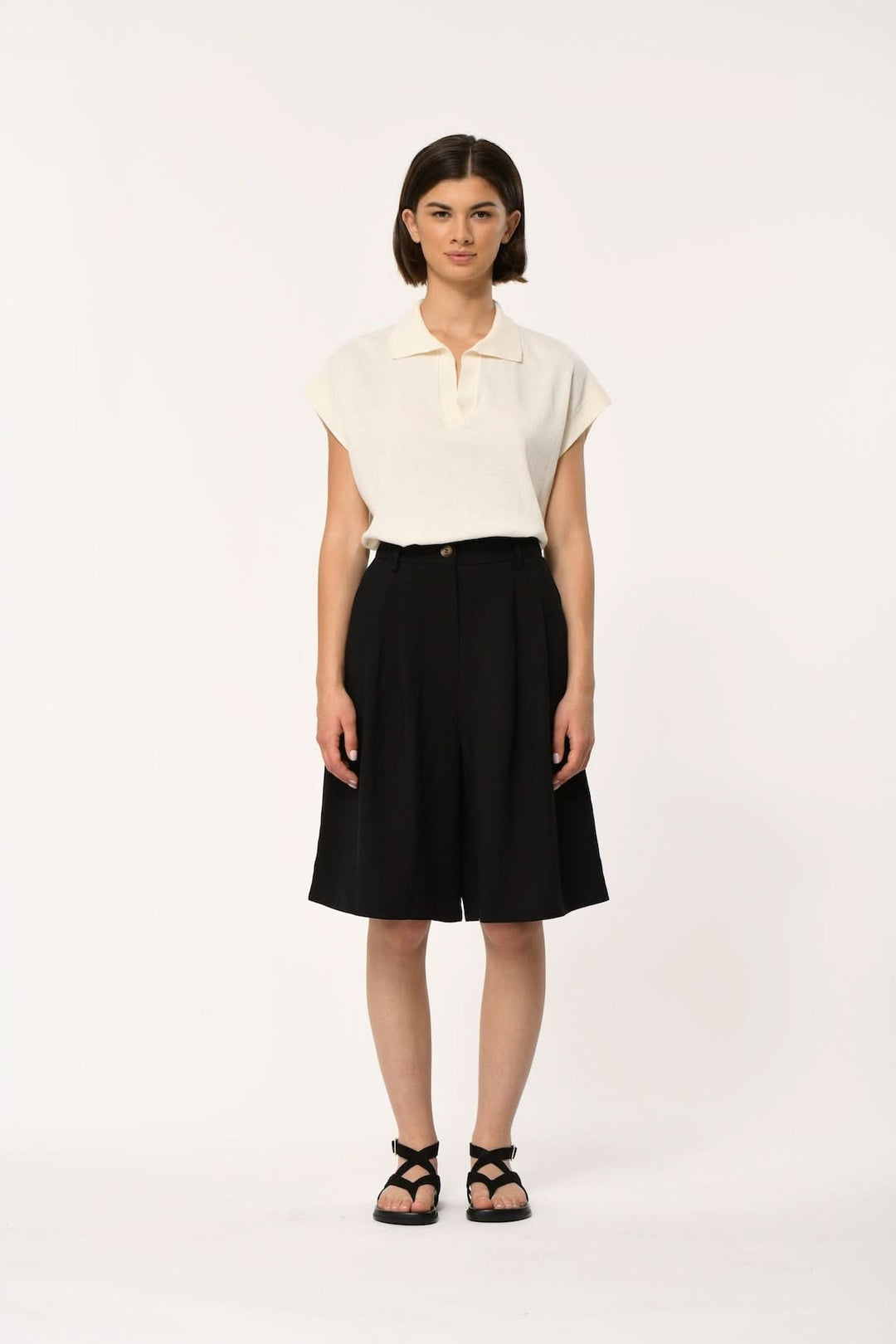 Femme portant Bermuda fluide taille haute LAO noir, coupe élégante et légère avec plis à l'avant, associé à un haut crème.