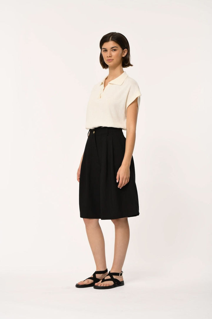 Femme portant le Bermuda fluide taille haute LAO en noir, coupe élégante avec plis à l&
