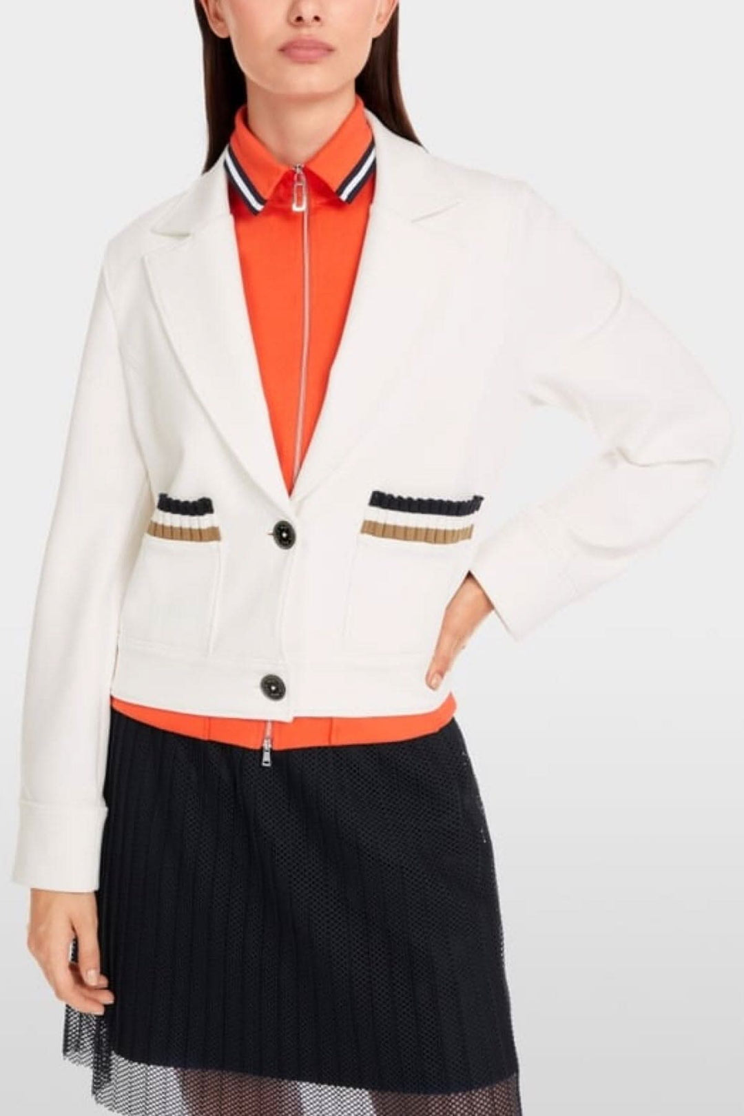Stylish white jersey blazer with wide sleeves and striped pocket detailing, paired with an orange top and black skort.