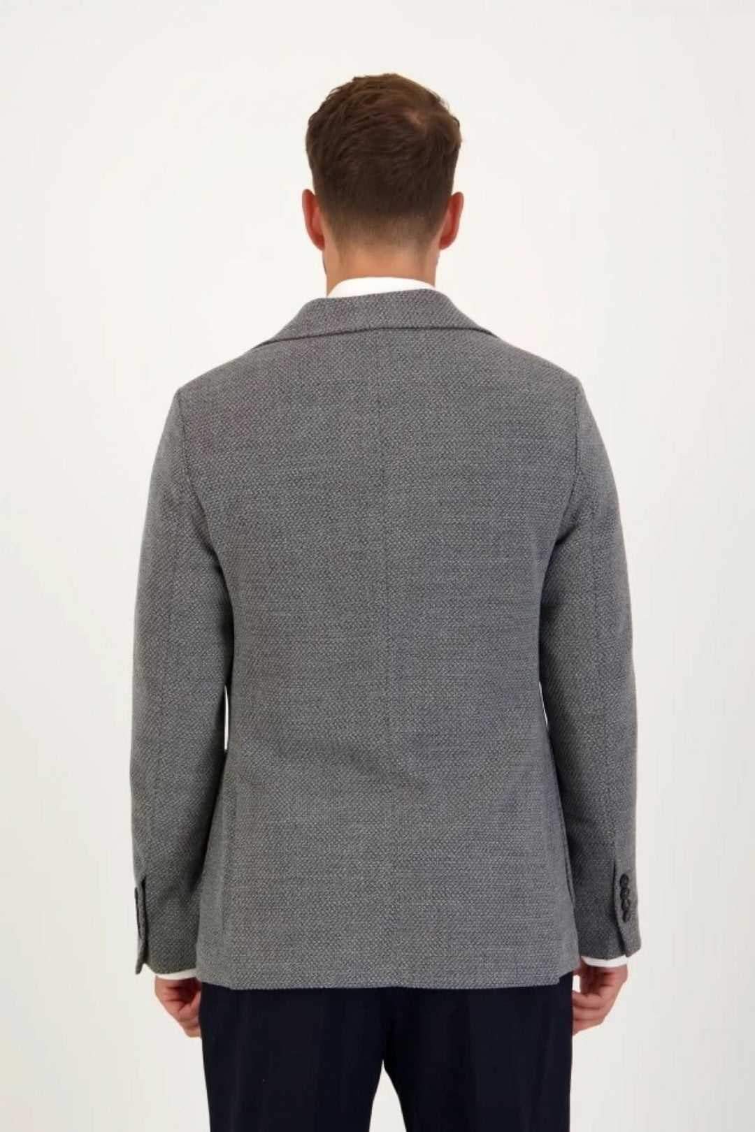 Homme portant un blazer en jersey de coton gris texturé avec coupe décontractée et élégante, vu de dos.