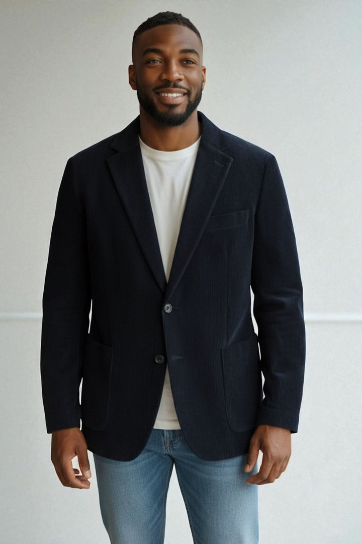 Homme portant un Blazer en velours côtelé bleu marine à deux boutons, combiné avec un t-shirt blanc et un jean, parfait pour l'automne.