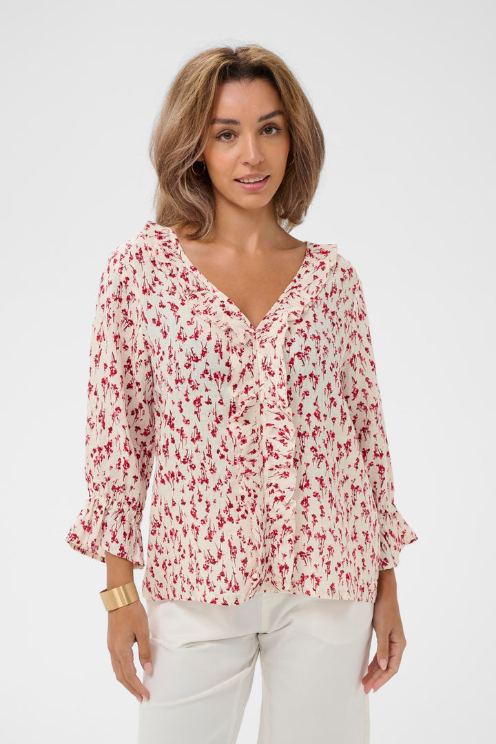 Blouse Bellis à motif délicat, encolure en V avec volants, manches trois-quarts, élégante et confortable pour un style quotidien.