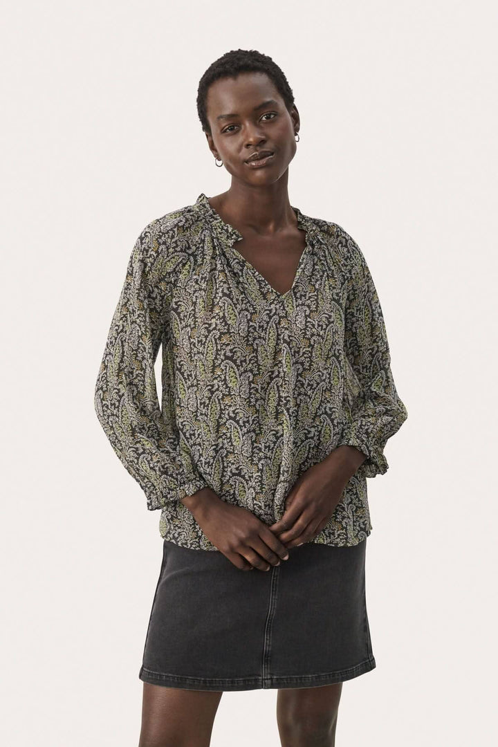 Blouse Elsia en viscose avec manches 3/4, imprimé coloré, portée avec une jupe noire.
