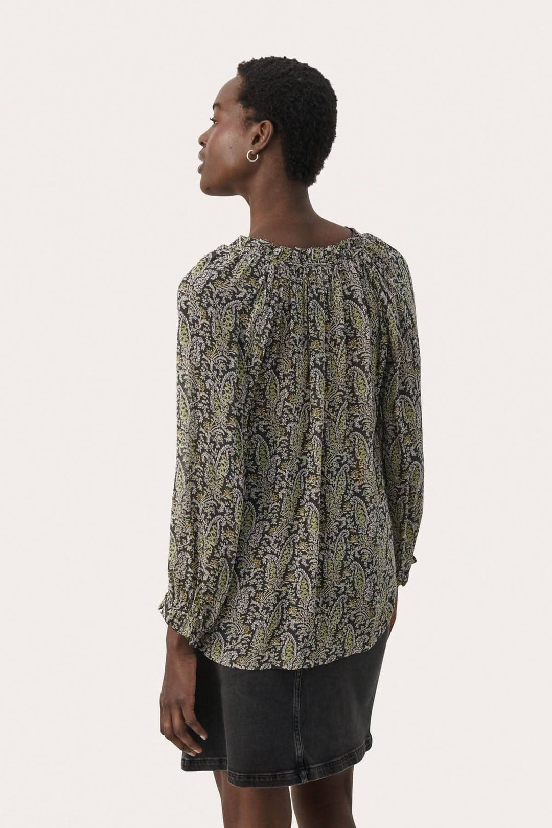 Blouse Elsia 100% viscose avec imprimé coloré, manches 3/4 et coupe décontractée portée avec une jupe.