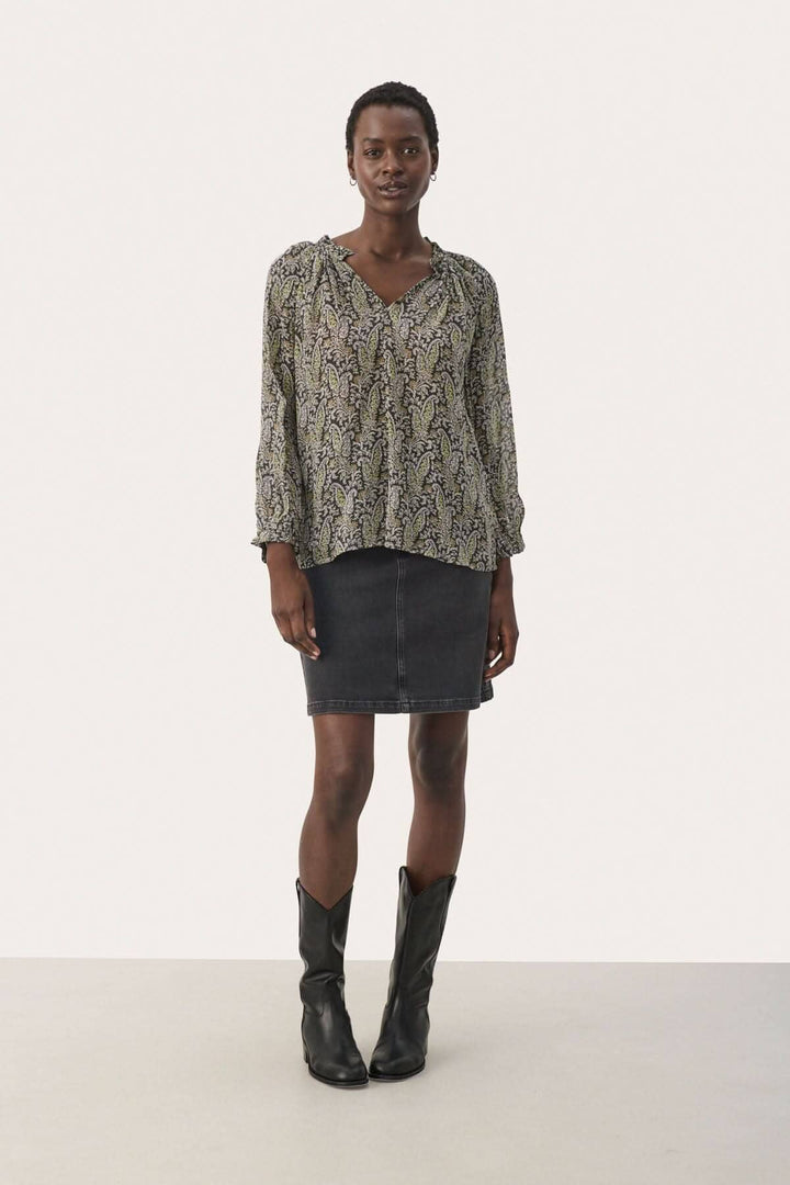 Blouse Elsia en viscose avec imprimé, manches 3/4, portée avec une jupe en jean et des bottes noires.