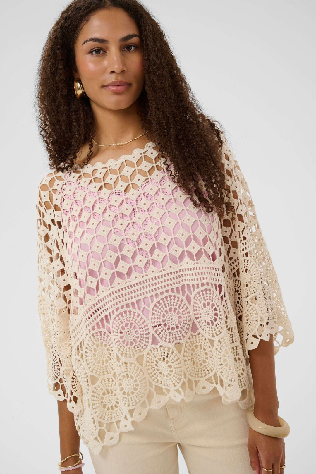 Blouse Gina en crochet ajouré avec motif délicat et ourlet festonné, manches larges pour une allure bohème féminine.