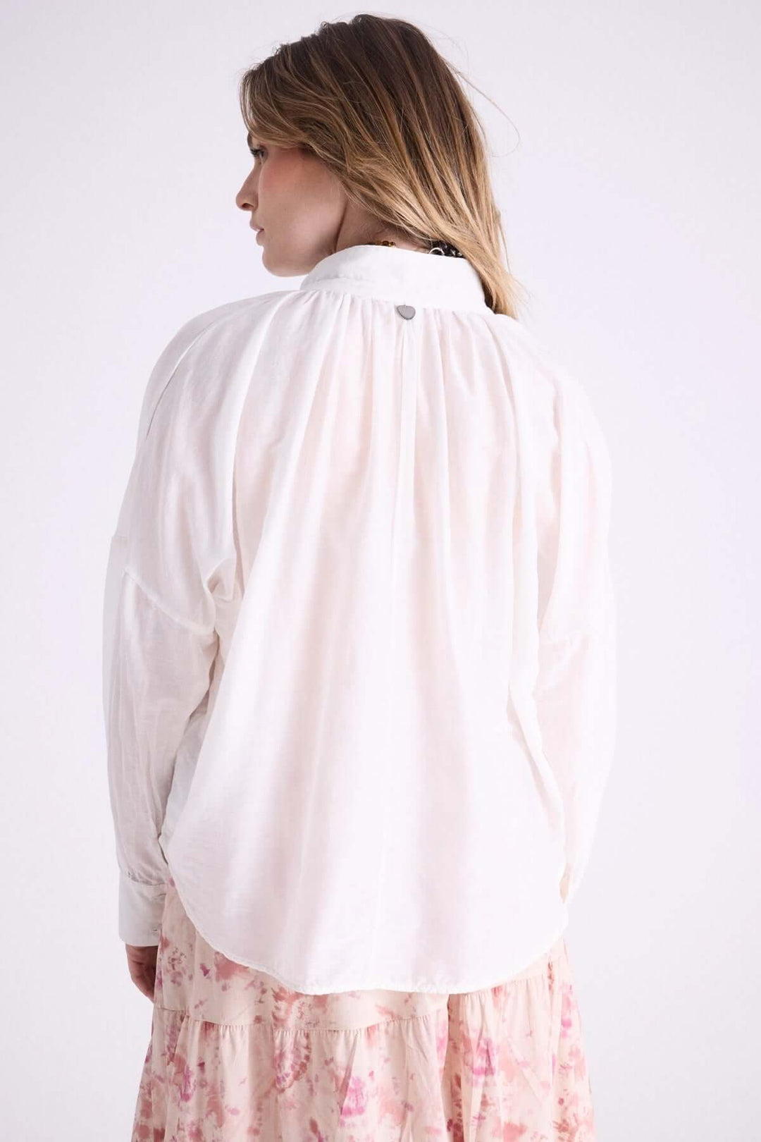 Vue arrière de la blouse légère à capuche Leonelle, montrant ses détails délicats et son tissu vaporeux.