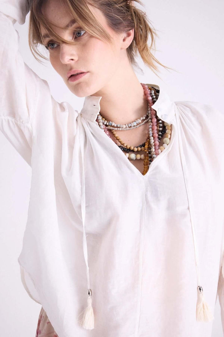 Blouse Leonelle légère à capuche, avec cordons à pompons, parfaite pour les journées estivales.