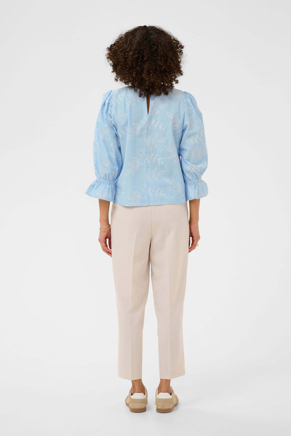 Blouse Marlee brodée à manches trois-quarts, vue arrière sur une femme, encolure ronde, porte des pantalons beiges.