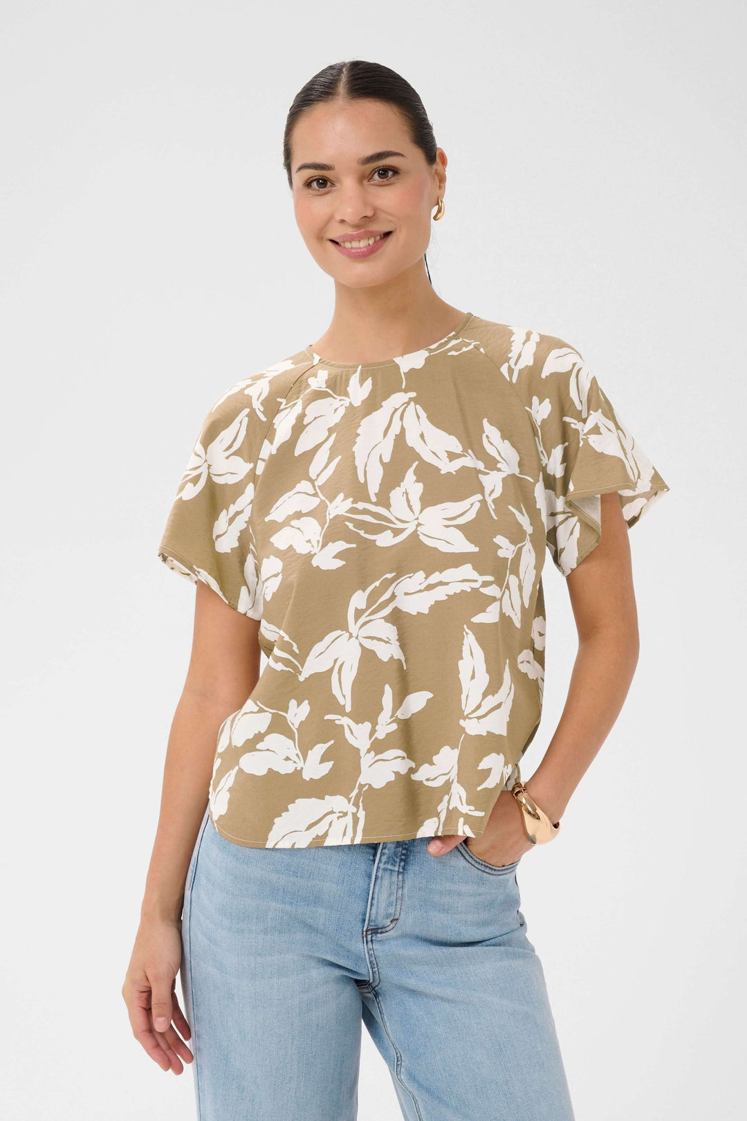 Femme portant la Blouse Marlo fluide à imprimé feuillage avec manches courtes, tenue décontractée parfaite pour l'été.