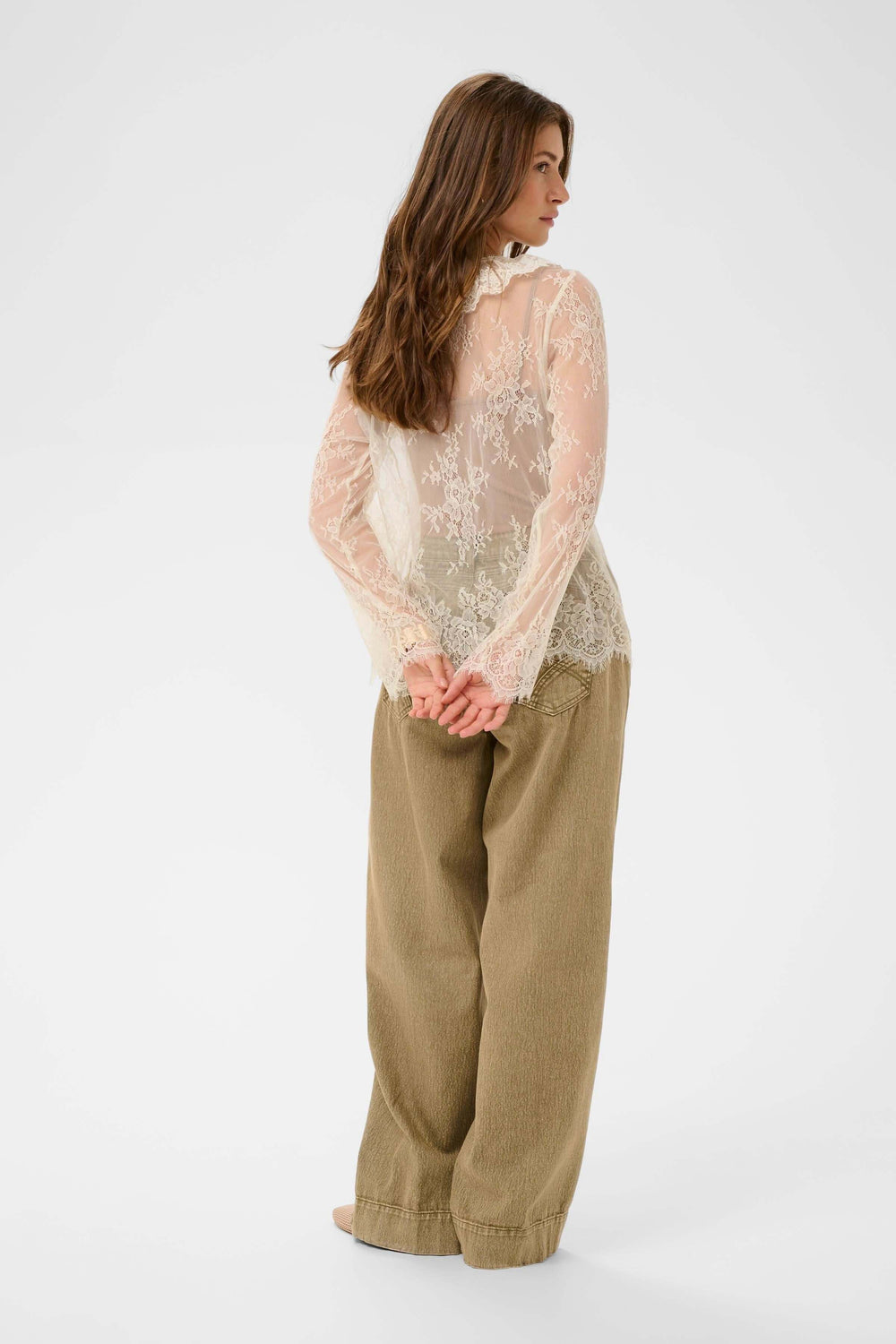 Blouse Mira en dentelle transparente à manches longues, montrant le design romantique et délicat de la dentelle fine et transparente.