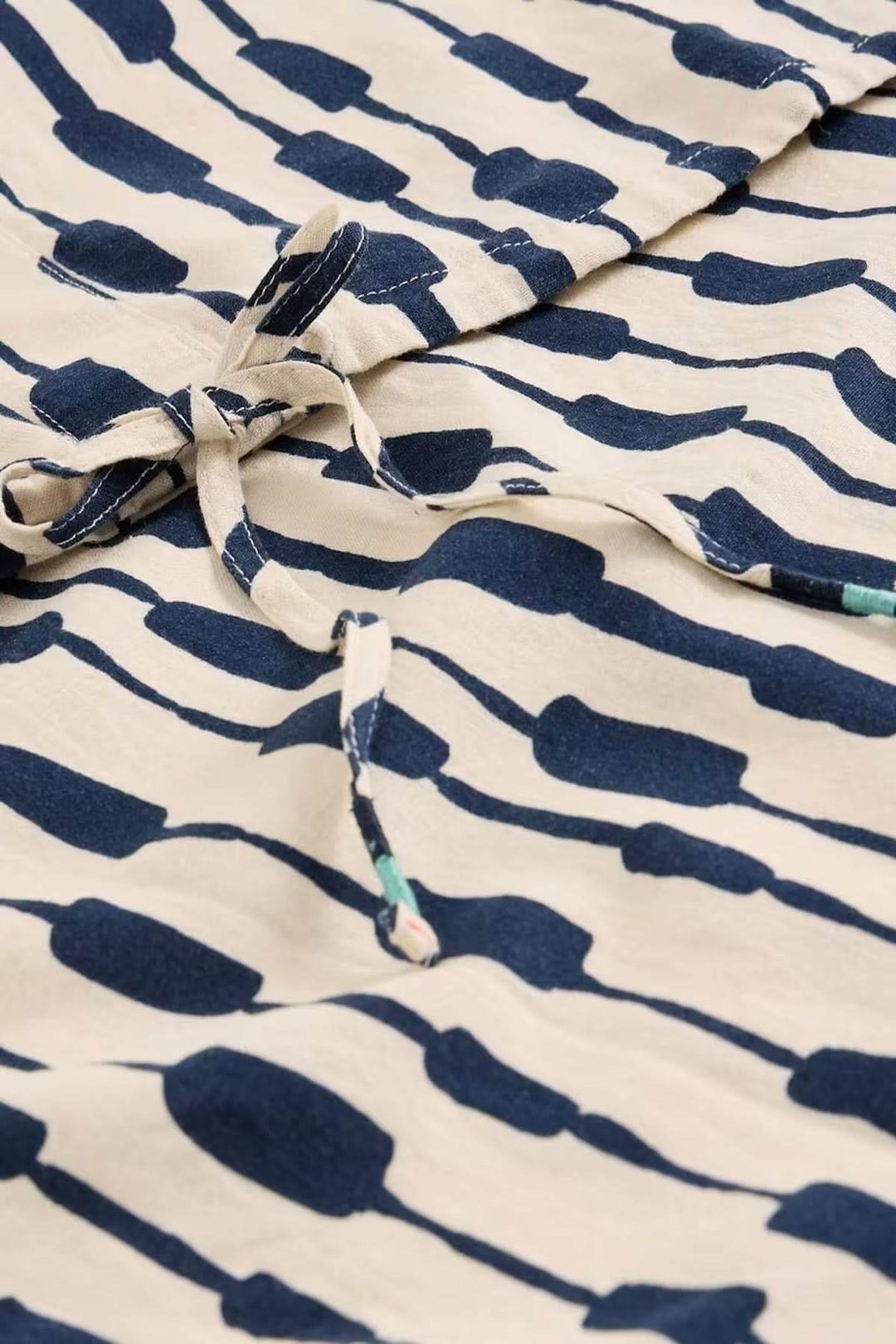Blouse Nicole en lin mélangé avec imprimé graphique moderne et lien à nouer observée de près, style raffiné et décontracté.