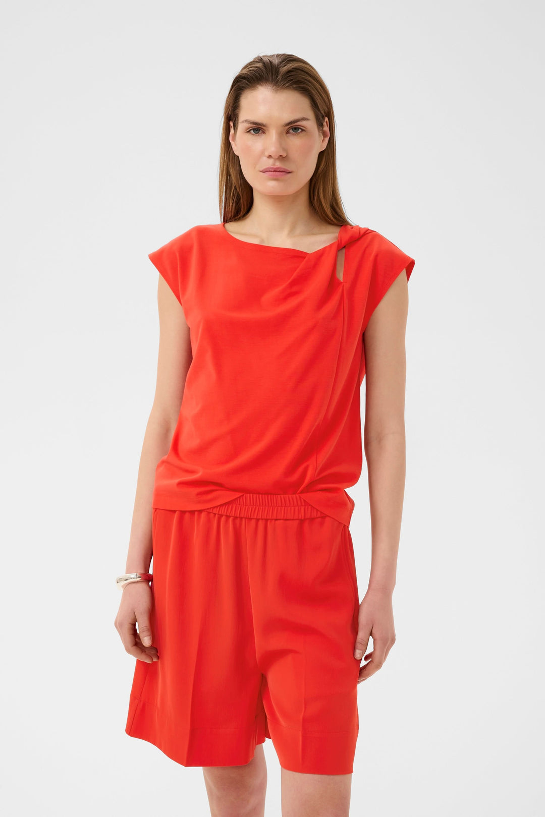 Blouse Pennie fluide à encolure drapée, manches courtes, couleur vive, pour un look moderne et sophistiqué.