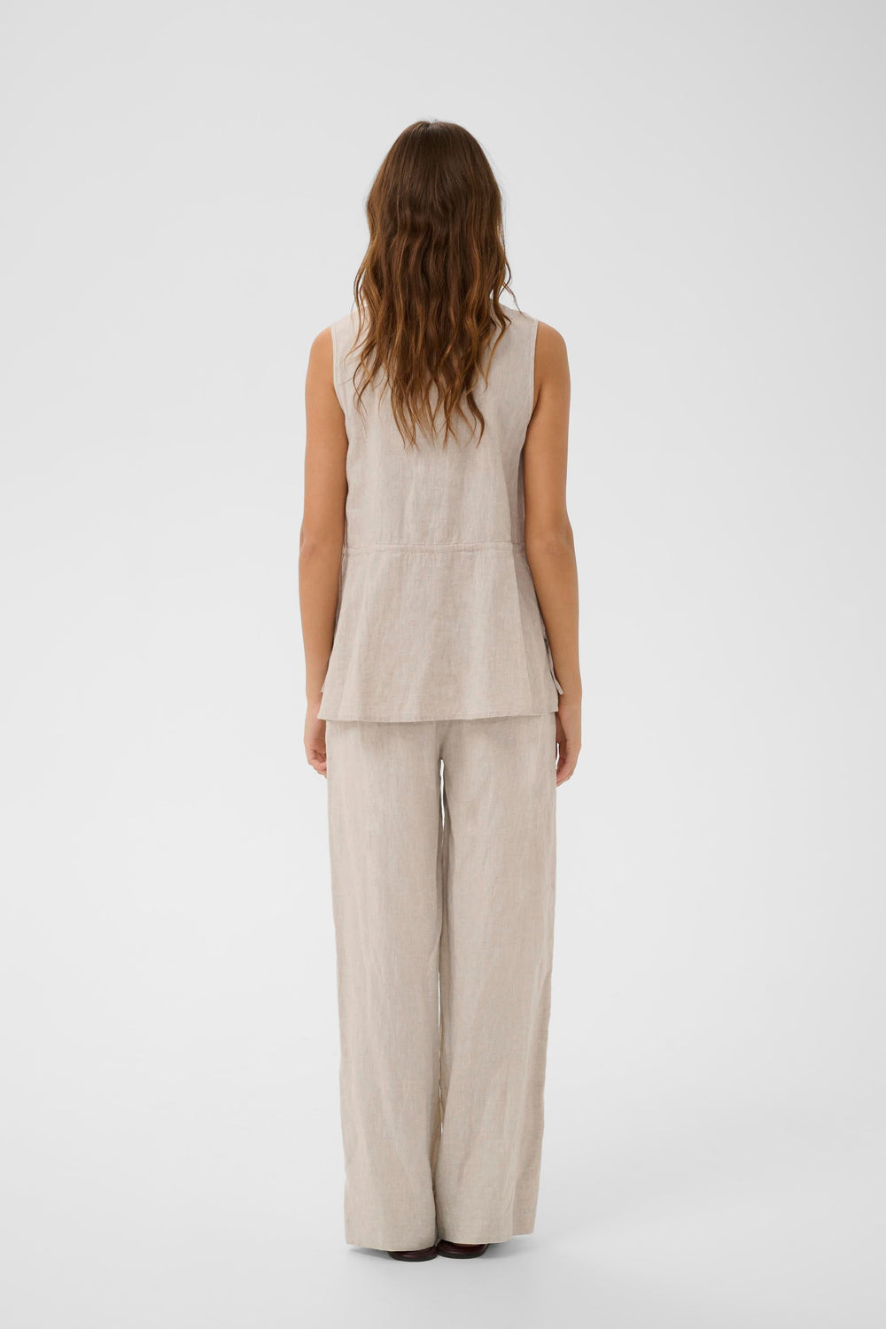 Blouse Rowan sans manches en lin avec coupe fluide et épurée, dos visible sur mannequin, facile à agencer avec différents styles.