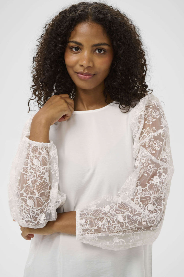 Blouse avec broderie à manches longues en dentelle, offrant une silhouette féminine et élégante pour un style quotidien raffiné.