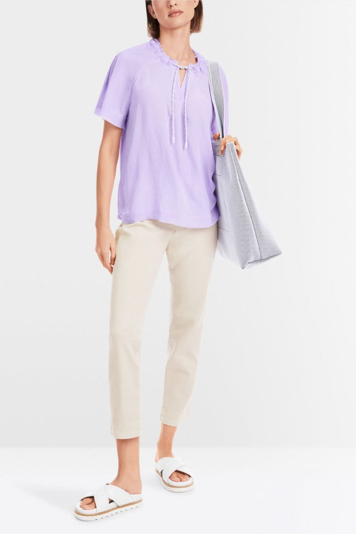 Blouse lilas avec cordon, manches raglan et ourlet à bords bruts, style casual.