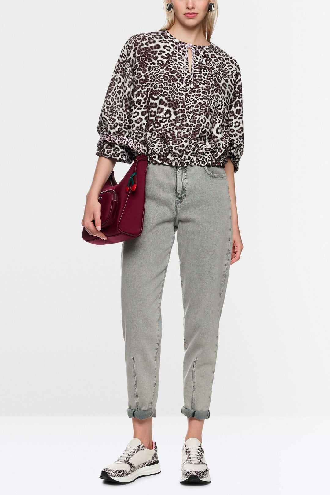 Blouse avec imprimé léopard moderne, ample, avec élastiques ajustables et encolure en V, portée par mannequin.