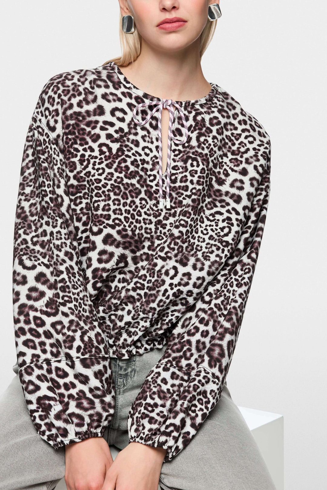 Blouse avec imprimé léopard moderne, coupe ample, encolure en V avec cordon de serrage, manche longue, idéale pour occasions variées.
