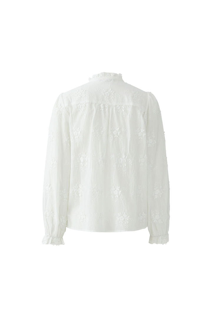 Blouse à broderies florales vue arrière avec col montant froncé et détails broderie délicats. Élégance et féminité assurées.