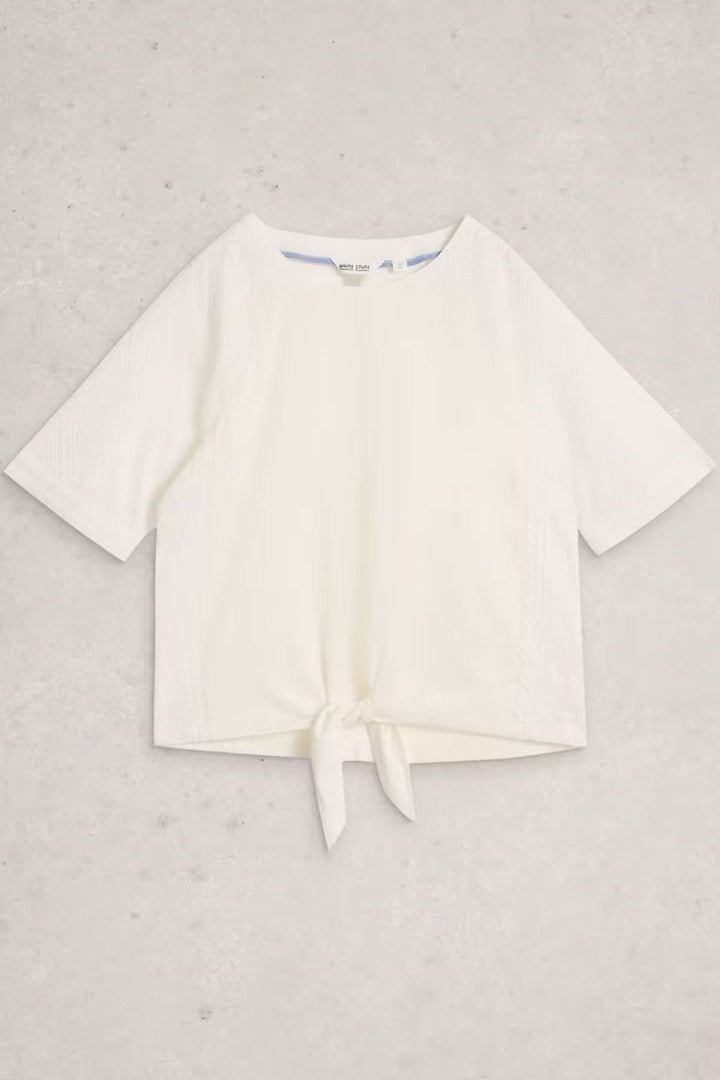 Blouse à col rond brodé avec ourlet à nœud sur fond blanc, manches courtes et lien à nouer sur la base pour un style moderne.