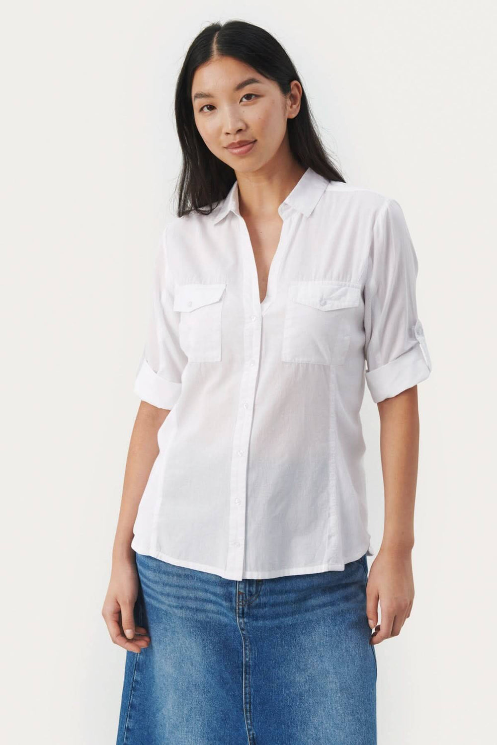 Blouse de coton Cortnia en blanc, col V, manches 3/4, poches plaquées, style décontracté.