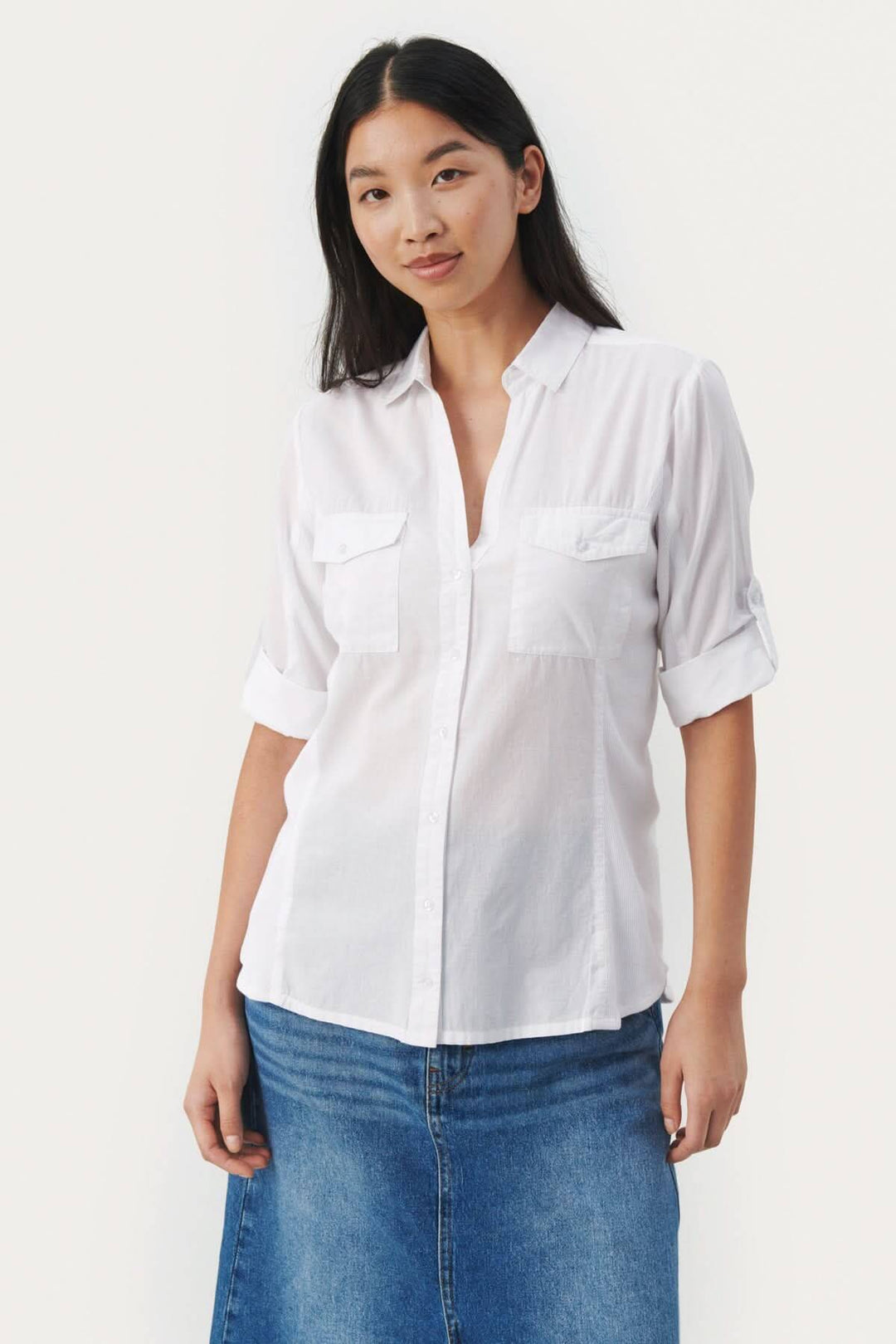 Blouse de coton Cortnia en blanc, col V, manches 3/4, poches plaquées, style décontracté.