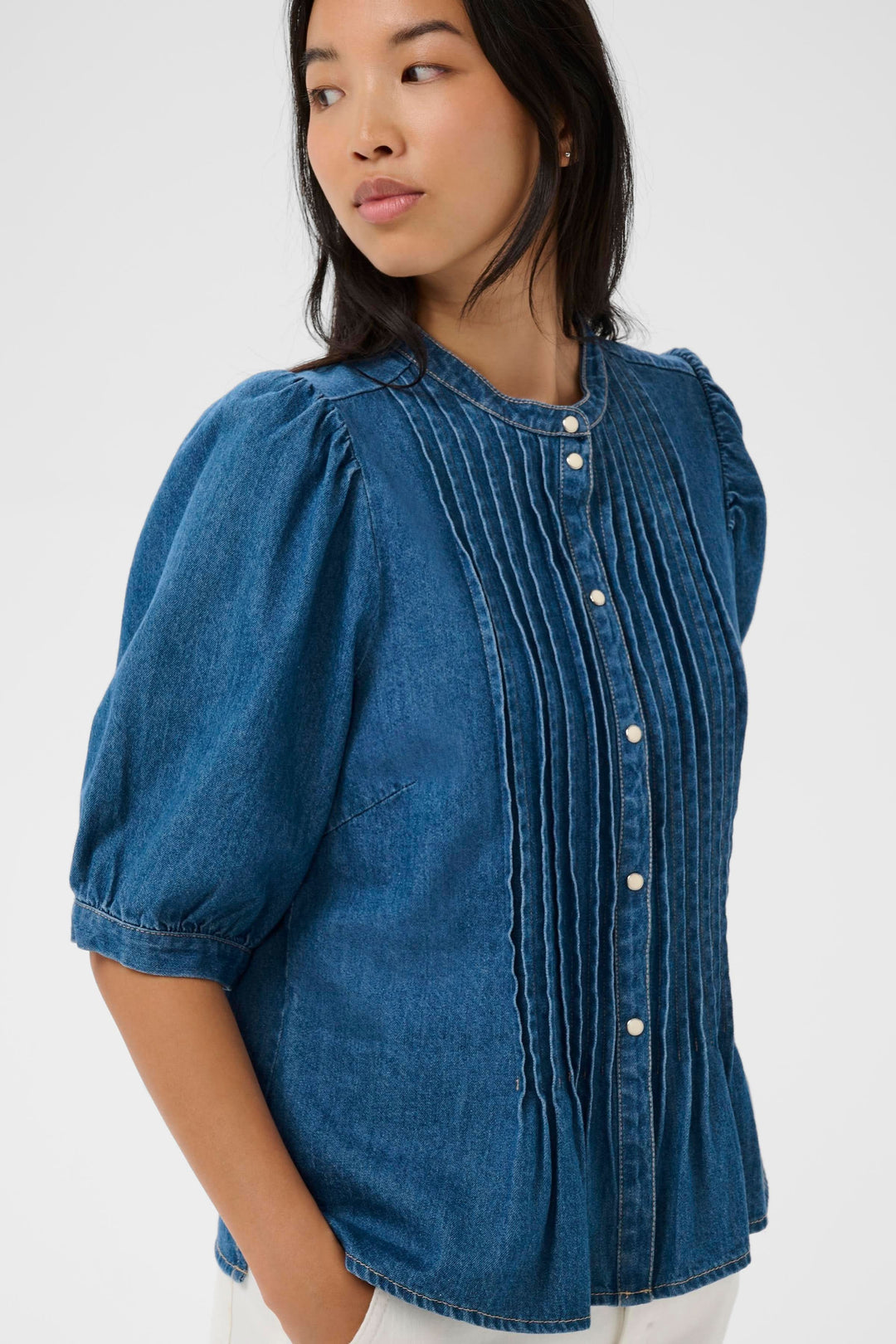 Blouse en denim Alesia avec plis décoratifs à l'avant, coupe évasée et encolure arrondie, idéale pour un look moderne.
